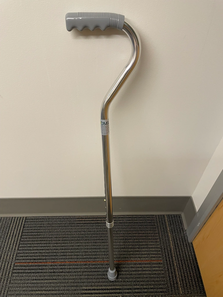 An orthopedic cane leaning against a wall